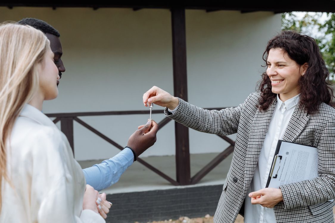 Real estate agent handing house keys to new homeowners