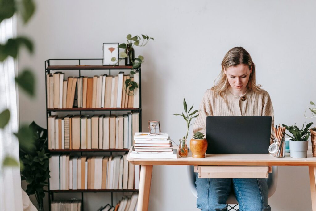 Person working on a laptop at a modern home desk — best AI tools for real estate agents