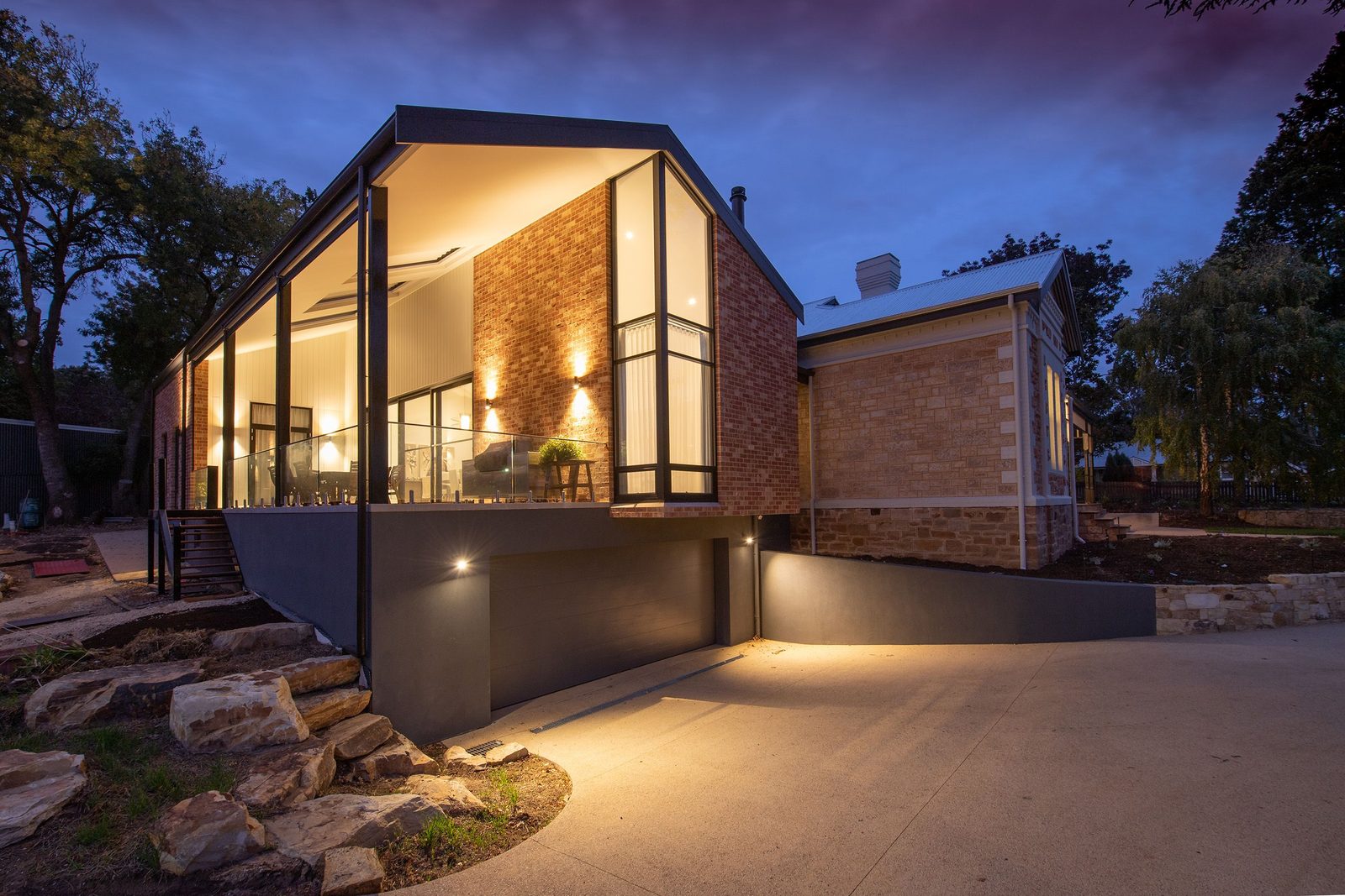 Modern luxury home exterior at dusk with warm lights