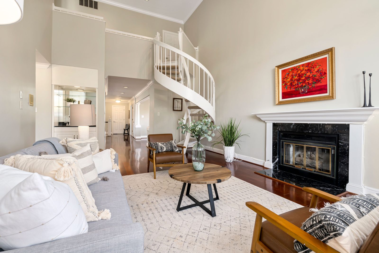 Bright furnished living room with spiral staircase — the finished look virtual staging tools create from empty-room photos